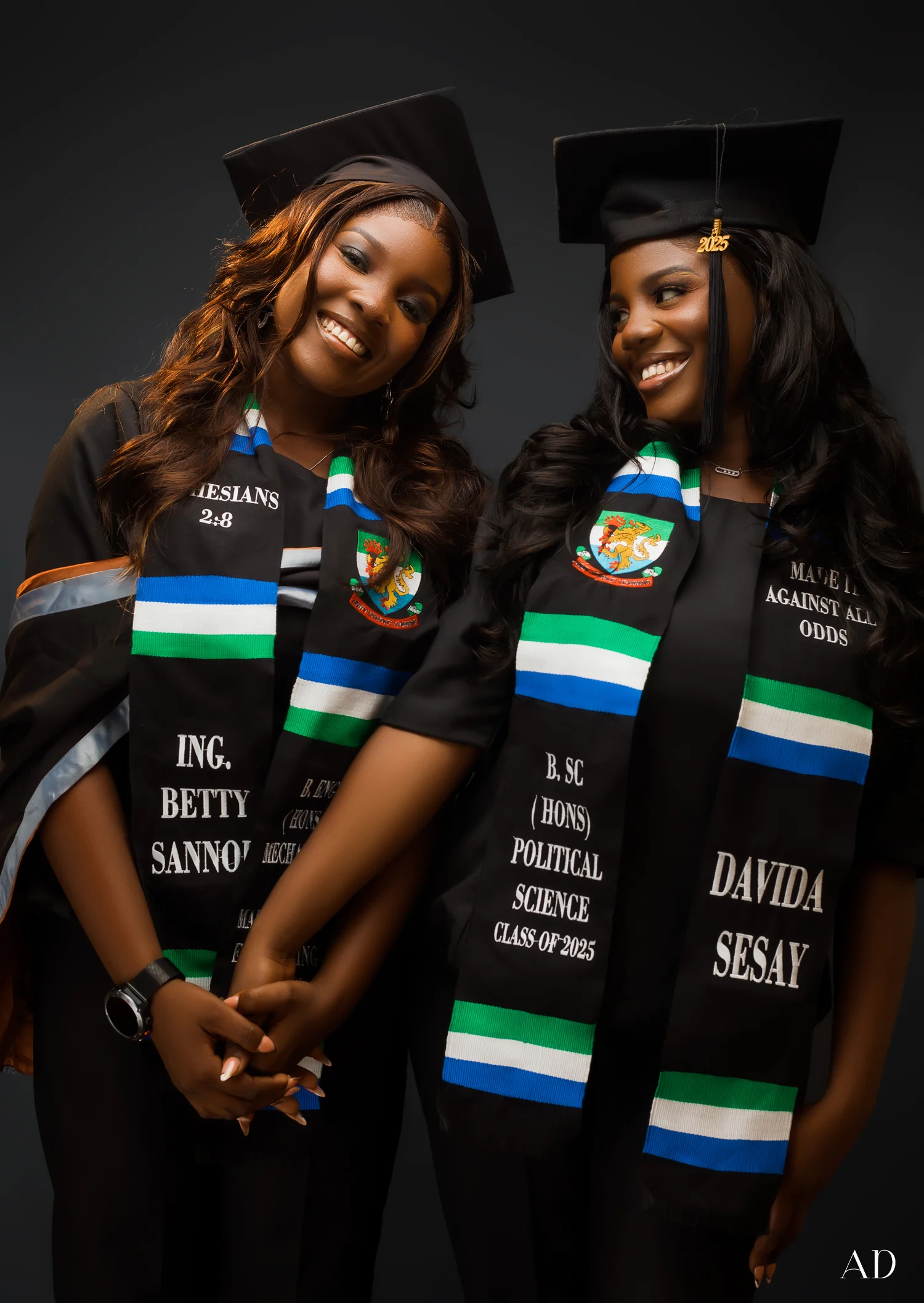 Two graduates celebrating together in an AD Studios portrait